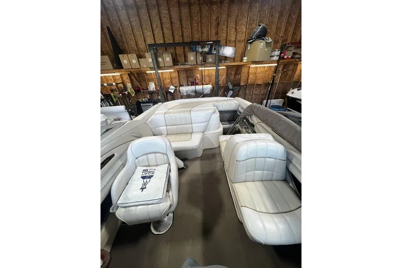 Slide: The Image of 1994 Sea Ray 220 boat interior with white leather seating in a storage area. - 4