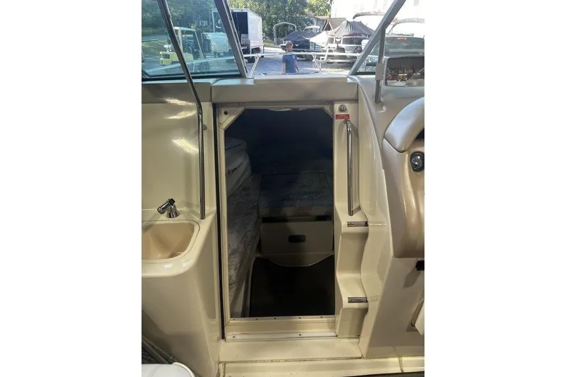 Slide: The Image of 1994 Sea Ray 220 boat interior cabin entrance with sink and seating area. - 9