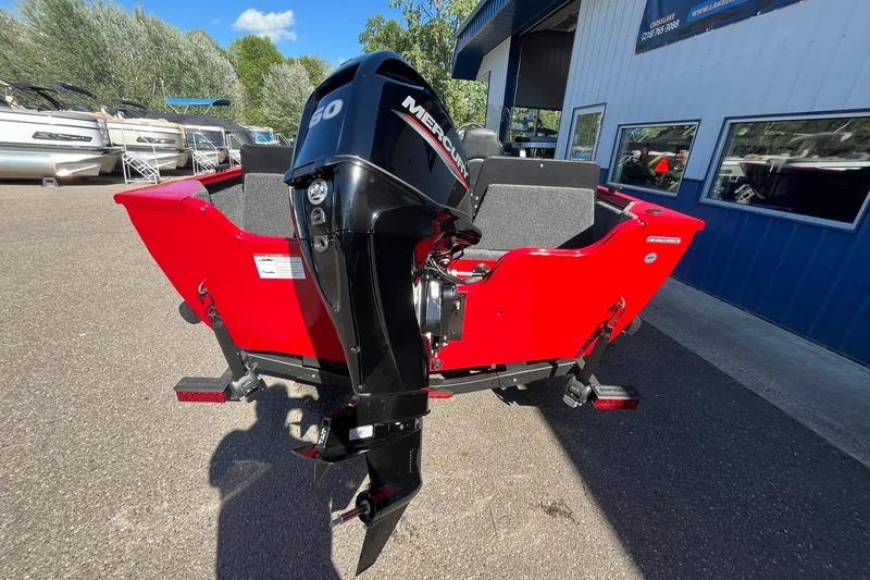 Slide: The Image of 2026 Crestliner 1650 Kodiak boat with Mercury outboard motor, vibrant red exterior. - 2