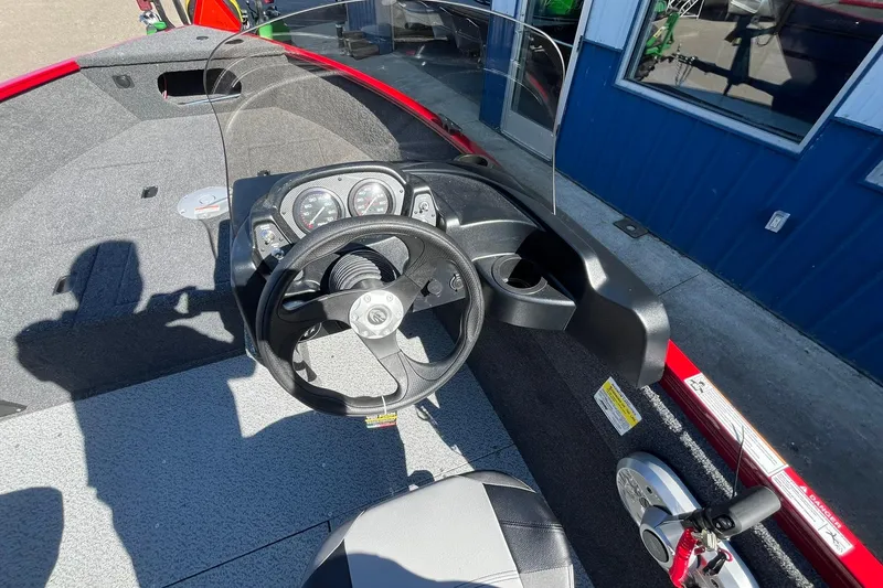 Slide: The Image of 2026 Crestliner 1650 Kodiak boat interior with steering wheel and dashboard controls. - 5