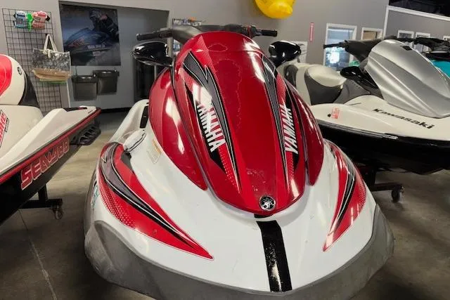 Slide: The Image of 2002 Yamaha WaveRunner FX Cruiser, red and white, displayed indoors with other watercraft. - 2
