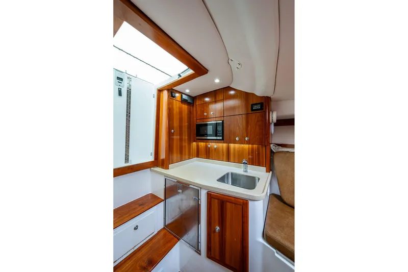 Slide: The Image of 2018 Albemarle 290 Express Fisherman cabin with wood cabinetry, sink, and microwave. - 23