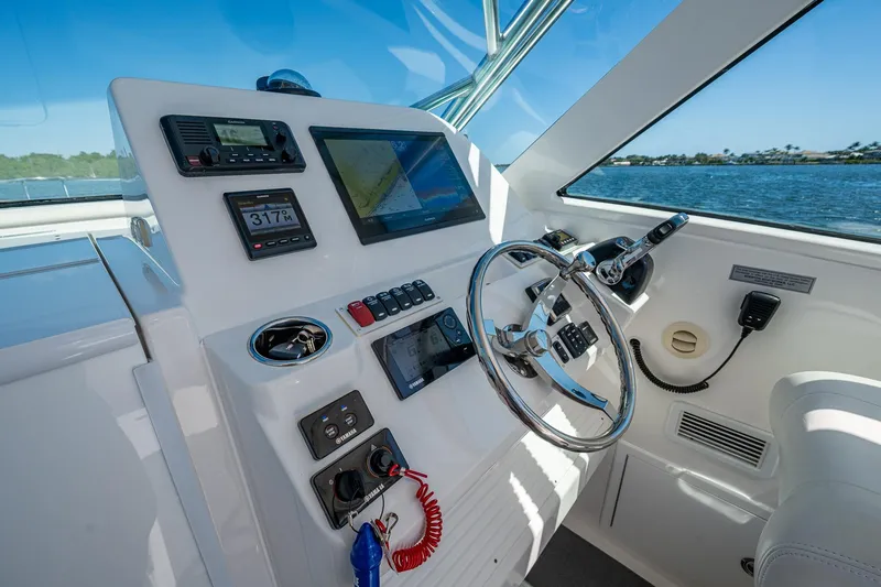 Slide: The Image of 2018 Albemarle 290 Express Fisherman helm with navigation controls and steering wheel. - 29