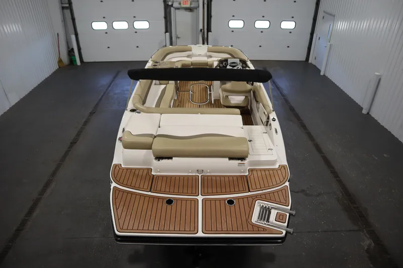 Slide: The Image of 2017 Starcraft 221 STARSTEP boat with tan seating and wood deck in a garage. - 10