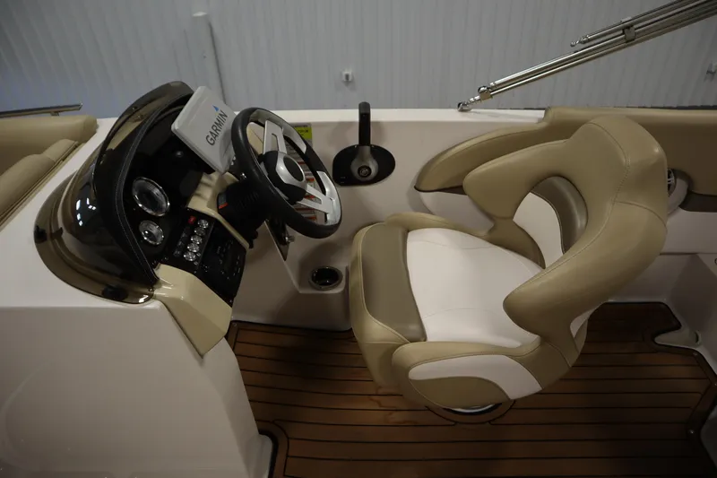 Slide: The Image of 2017 Starcraft 221 STARSTEP boat cockpit with Garmin navigation and beige captain's chair. - 20