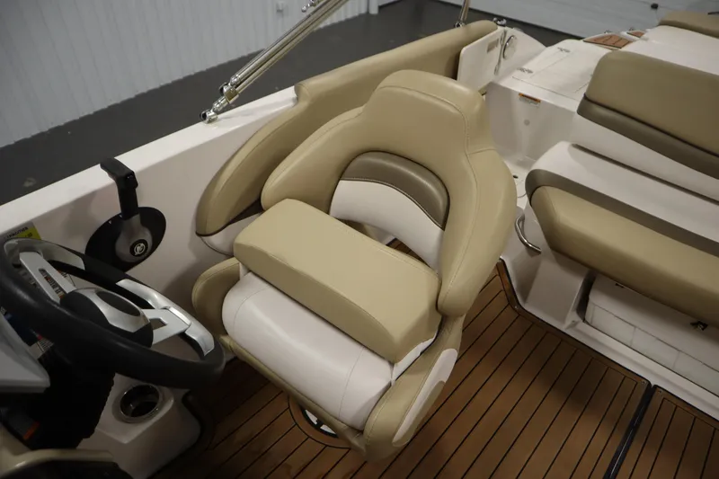Slide: The Image of 2017 Starcraft 221 STARSTEP boat interior with beige seating and steering wheel. - 35