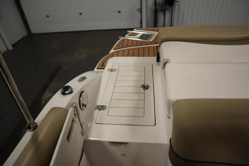 Slide: The Image of 2017 Starcraft 221 STARSTEP boat interior with cushioned seating and storage compartment. - 48