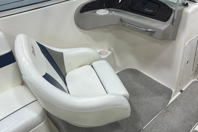 Slide: The Image of Interior of a 2000 Rinker 212 Captiva Bowrider with white seating and gray carpet. - 14