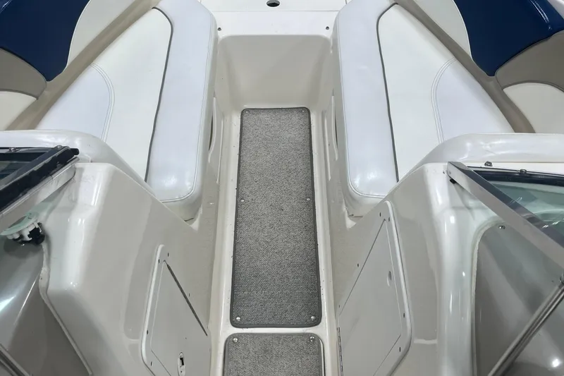 Slide: The Image of 2000 Rinker 212 Captiva Bowrider interior with white seating and carpeted floor. - 16