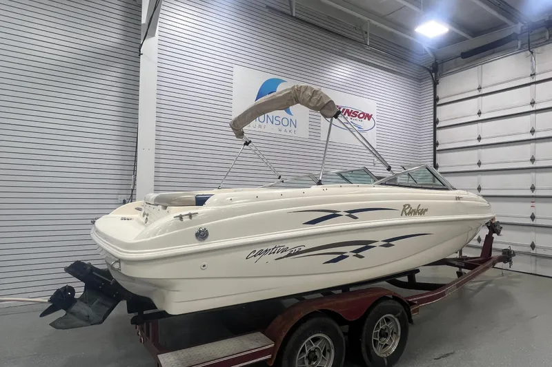 Slide: The Image of 2000 Rinker 212 Captiva Bowrider boat on trailer in indoor showroom. - 2