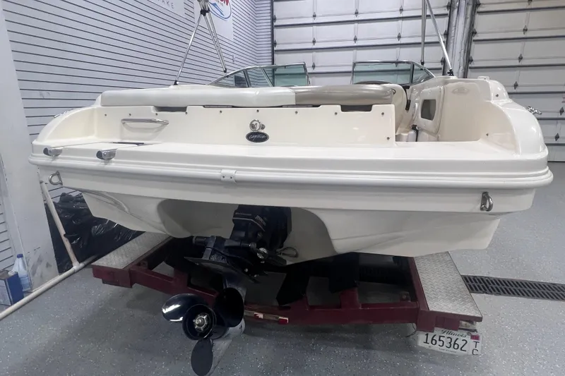 Slide: The Image of 2000 Rinker 212 Captiva Bowrider boat in a garage, rear view. - 3