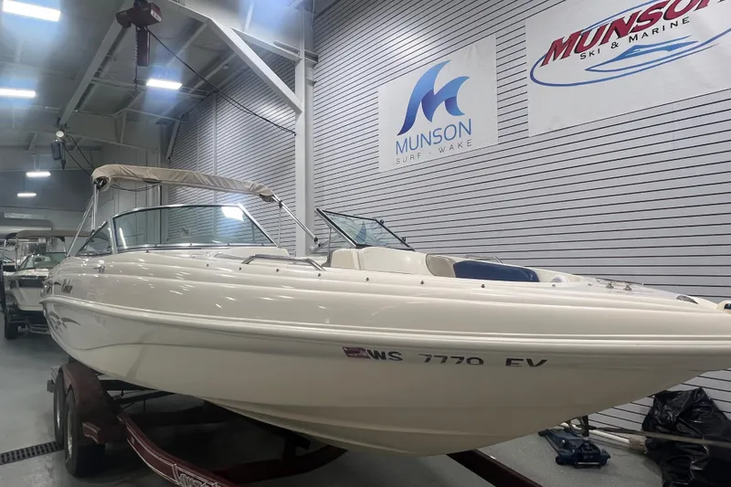 Slide: The Image of 2000 Rinker 212 Captiva Bowrider boat in showroom, Munson Surf & Wake signage. - 4