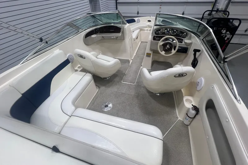 Slide: The Image of 2000 Rinker 212 Captiva Bowrider interior with white seating and modern dashboard. - 8