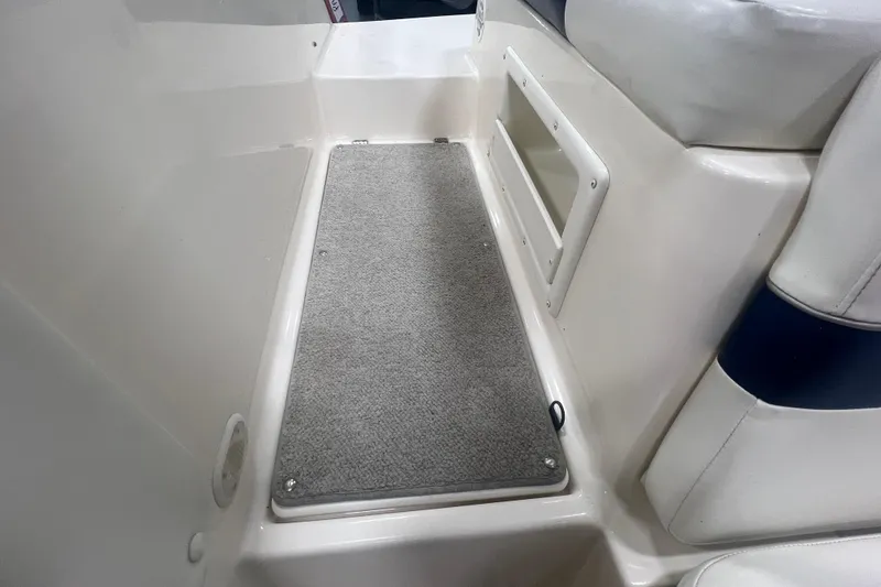 Slide: The Image of Interior view of a 2000 Rinker 212 Captiva Bowrider boat with carpeted flooring. - 9