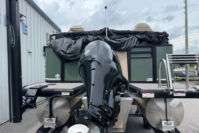 Slide: The Image of 2024 Viaggio 18 FISH pontoon boat with powerful outboard motor, docked outdoors. - 19