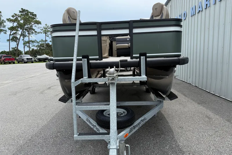 Slide: The Image of 2024 Viaggio 18 FISH boat on trailer, parked outdoors near a metal building. - 2