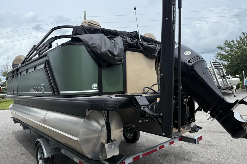 Slide: The Image of 2024 Viaggio 18 FISH pontoon boat on trailer, featuring a powerful outboard motor. - 21