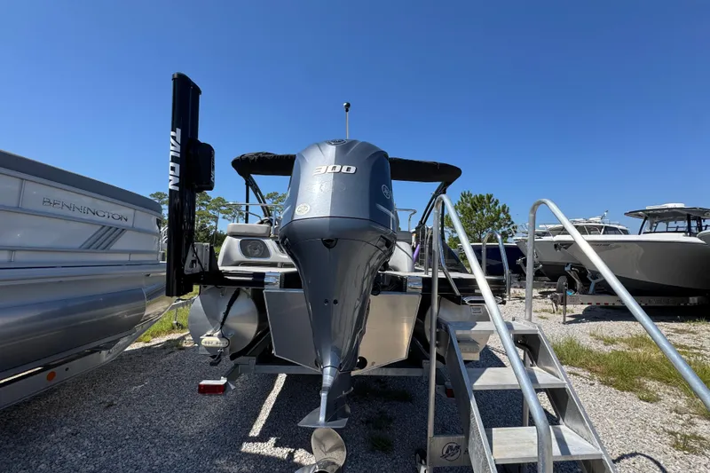 Slide: The Image of 2021 Bennington 25 RTSB boat with powerful engine, parked outdoors under clear blue sky. - 11