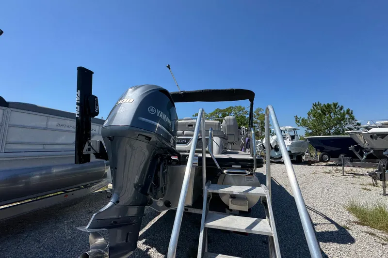 Slide: The Image of 2021 Bennington 25 RTSB pontoon boat with Yamaha 300 engine, parked outdoors. - 12