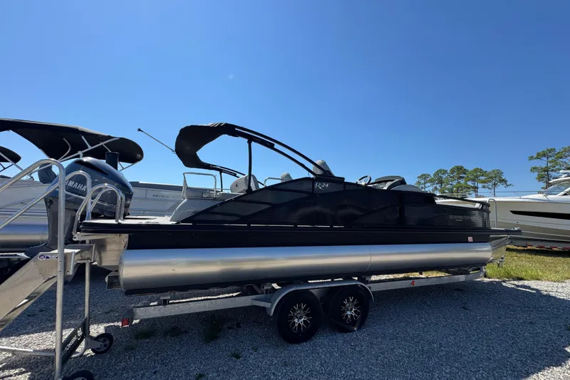 Slide: The Image of 2021 Bennington 25 RTSB pontoon boat on trailer under clear blue sky. - 15