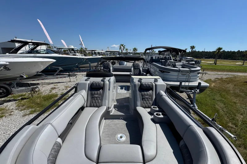 Slide: The Image of 2021 Bennington 25 RTSB pontoon boat with luxurious seating, displayed outdoors. - 18