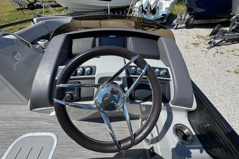 Slide: The Image of Steering wheel and dashboard of 2021 Bennington 25 RTSB boat, featuring modern controls. - 22