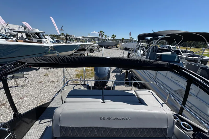 Slide: The Image of 2021 Bennington 25 RTSB pontoon boat displayed in a marina under clear blue skies. - 31