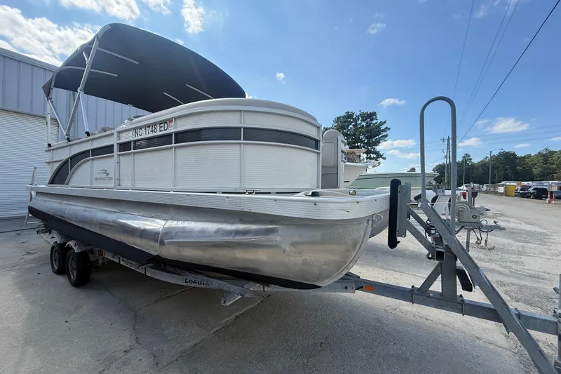Slide: The Image of 2016 Bennington 22 SSRX pontoon boat on trailer under blue sky. - 10