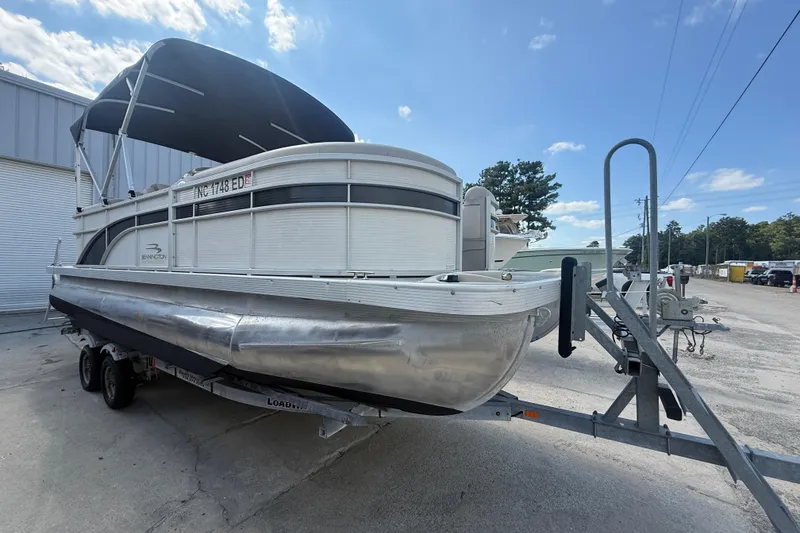 Slide: The Image of 2016 Bennington 22 SSRX pontoon boat on trailer, parked outdoors under blue sky. - 11