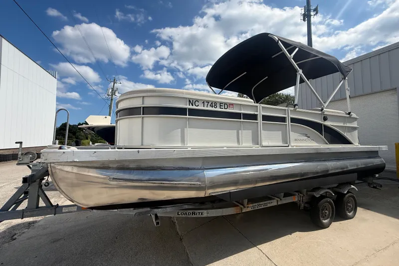 Slide: The Image of 2016 Bennington 22 SSRX pontoon boat on trailer under blue sky. - 13