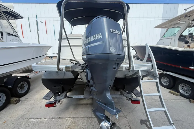 Slide: The Image of 2016 Bennington 22 SSRX pontoon boat with Yamaha 150 outboard motor, docked on trailer. - 31