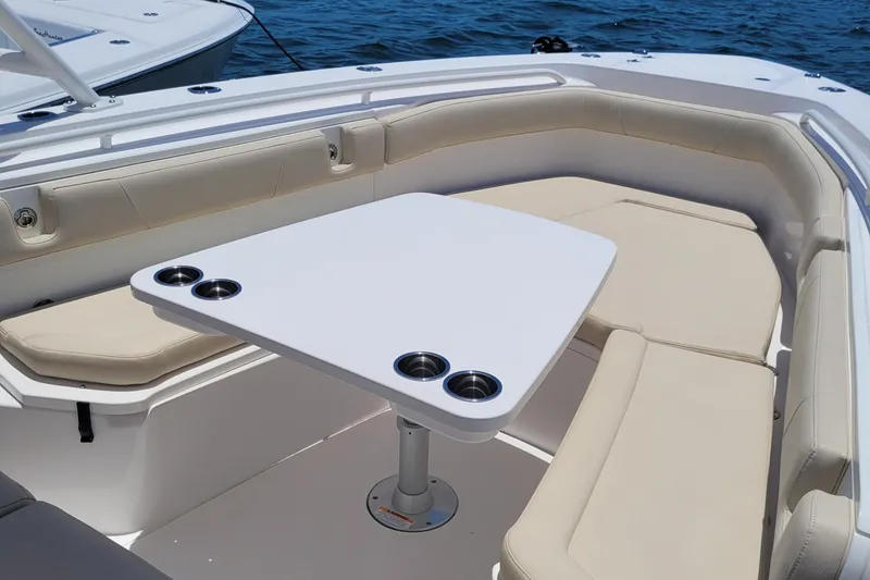 Slide: The Image of 2018 Everglades 355 Center Console boat with cushioned seating and table on open water. - 15