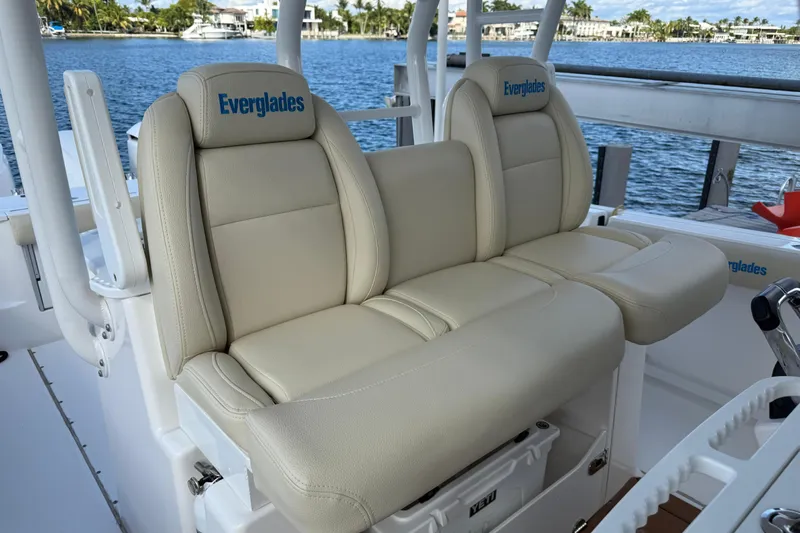 Slide: The Image of 2018 Everglades 355 Center Console boat seats with beige upholstery, dockside view. - 17