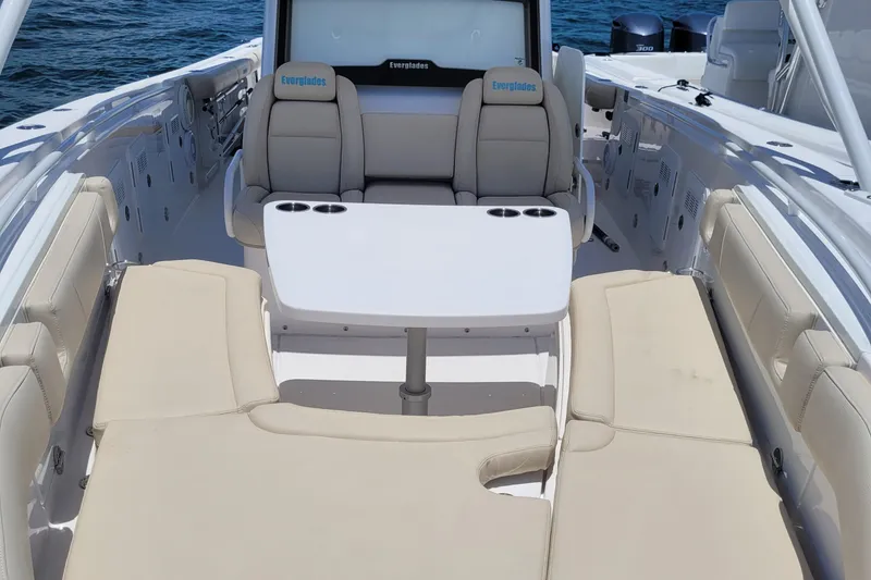 Slide: The Image of 2018 Everglades 355 Center Console boat interior with seating and table on open water. - 18