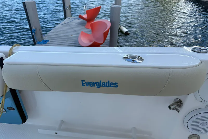 Slide: The Image of 2018 Everglades 355 Center Console boat with padded armrest, dock, and water view. - 21