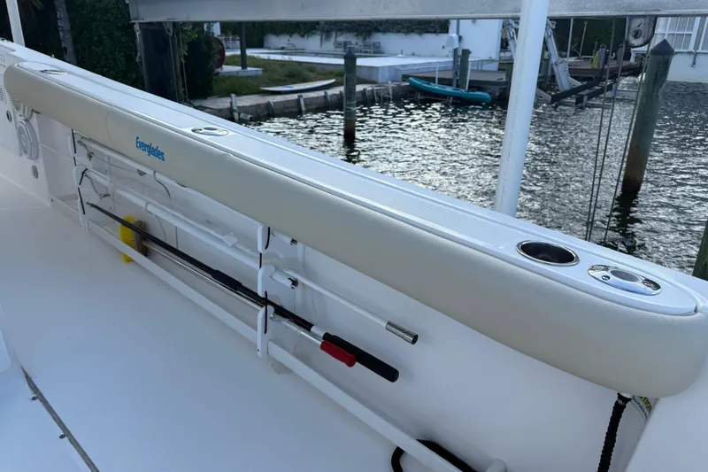 Slide: The Image of 2018 Everglades 355 Center Console boat with rod holders and cup holders by the water. - 24