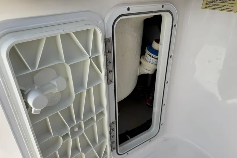 Slide: The Image of Open hatch on 2018 Everglades 355 Center Console boat, revealing interior components. - 27
