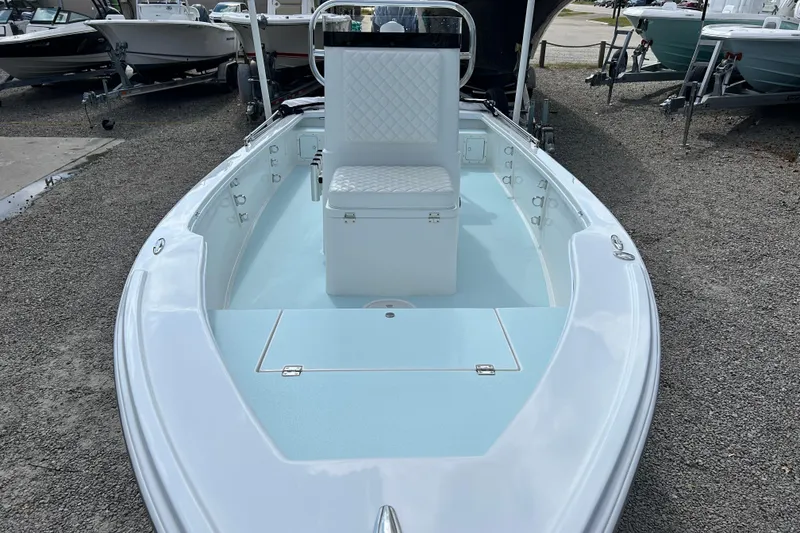 Slide: The Image of 2025 Dragonfly Boatworks Spanish Wells 21, sleek design, white and blue interior, docked outdoors. - 10