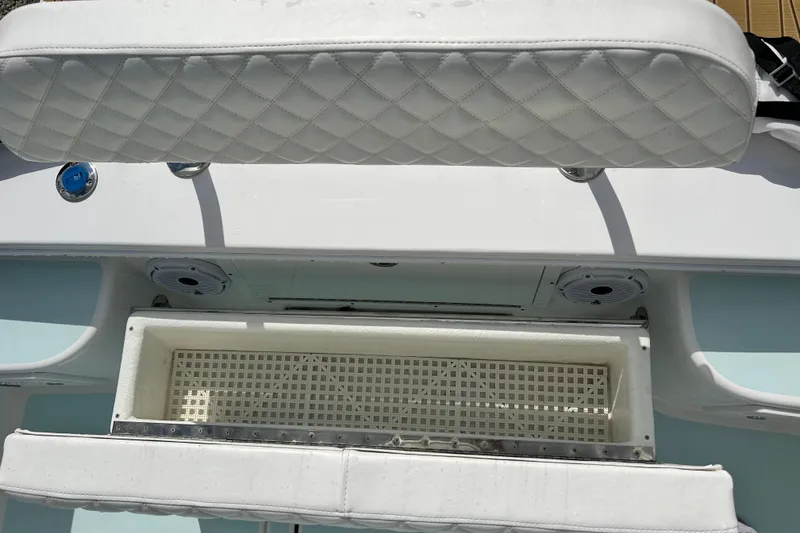 Slide: The Image of 2025 Dragonfly Boatworks Spanish Wells 21 interior with white cushioned seating and storage compartment. - 26