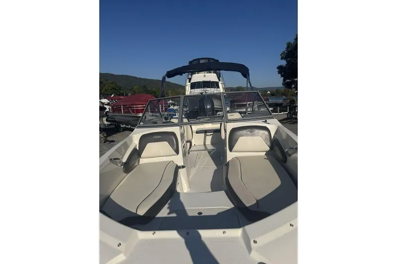Slide: The Image of 2016 Stingray 191DC (OB) boat with open seating, docked under clear blue sky. - 15