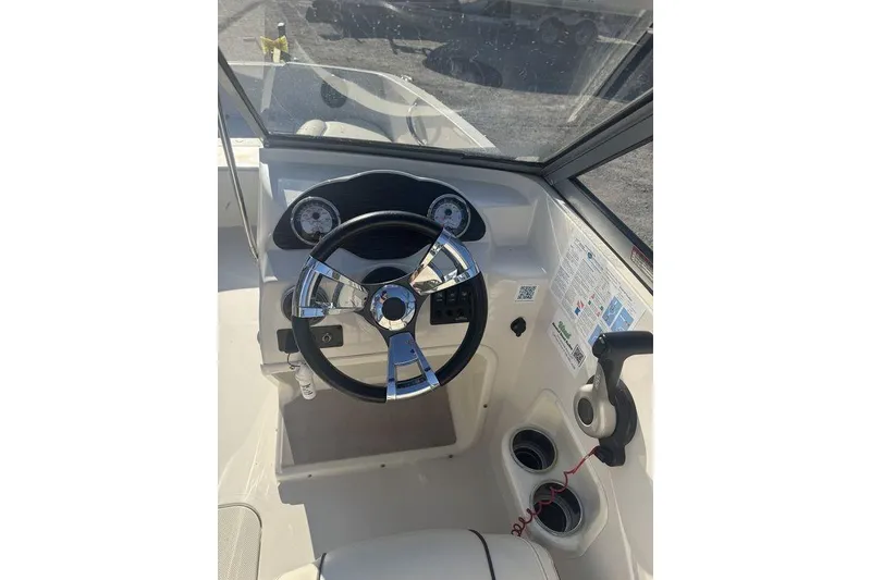 Slide: The Image of 2016 Stingray 191DC (OB) boat dashboard with steering wheel and controls. - 16