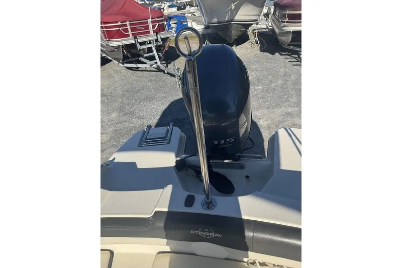 Slide: The Image of 2016 Stingray 191DC (OB) boat with Yamaha 115 outboard motor, parked among other boats. - 6