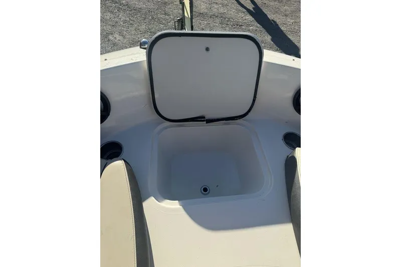 Slide: The Image of 2016 Stingray 191DC (OB) boat storage compartment with open lid and cup holders. - 9