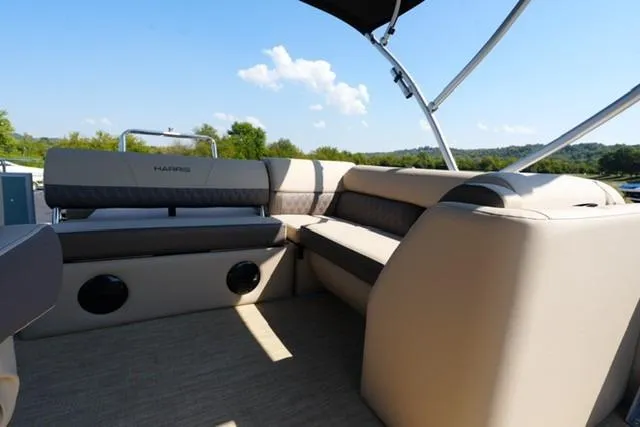 Slide: The Image of 2026 Harris Cruiser 210 boat interior with beige seating and scenic outdoor view. - 13