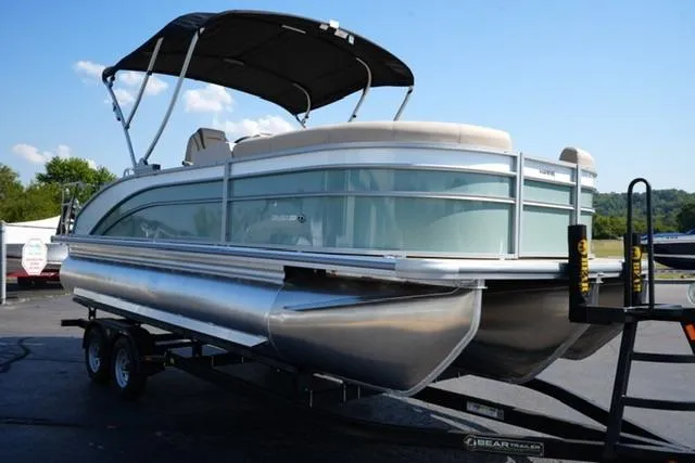 Slide: The Image of 2026 Harris Cruiser 210 pontoon boat on trailer with canopy, parked outdoors. - 3