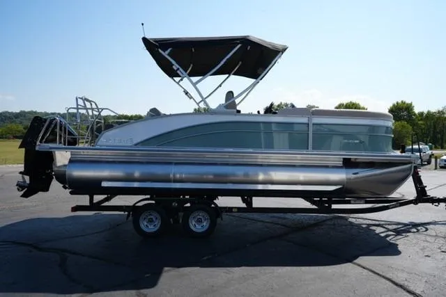 Slide: The Image of 2026 Harris Cruiser 210 pontoon boat on trailer, parked outdoors. - 4