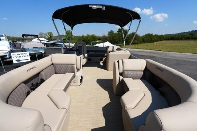 Slide: The Image of 2026 Harris Cruiser 210 pontoon boat with spacious seating and canopy, parked outdoors. - 8