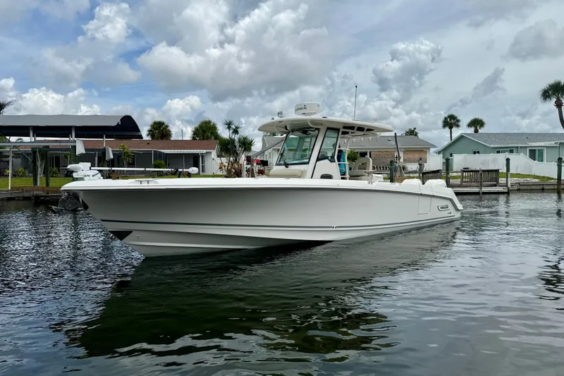 The Image of 2019 Boston Whaler 330 Outrage boat docked in a scenic waterfront setting. - 0