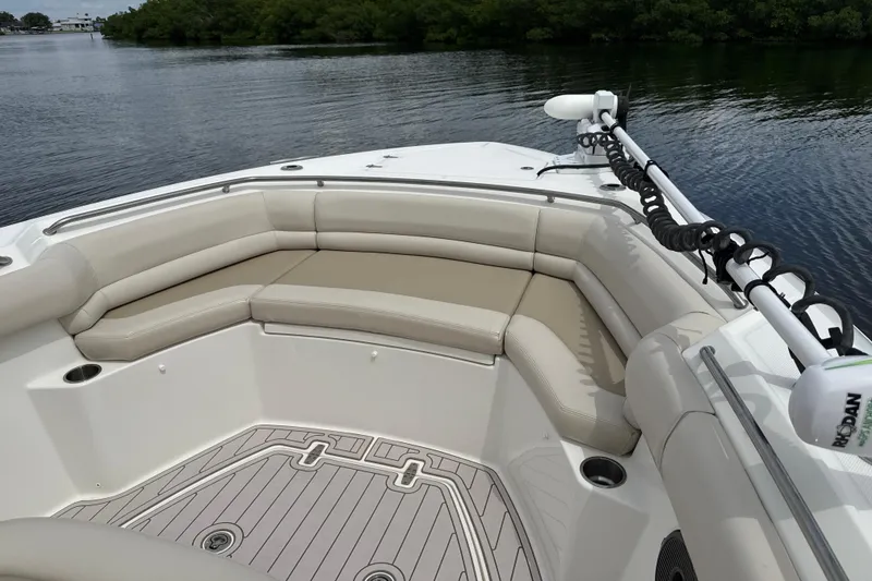 Slide: The Image of 2019 Boston Whaler 330 Outrage boat interior with cushioned seating and water view. - 10