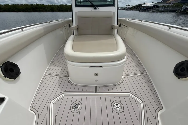 Slide: The Image of 2019 Boston Whaler 330 Outrage boat interior with cushioned seating and sleek deck design. - 12